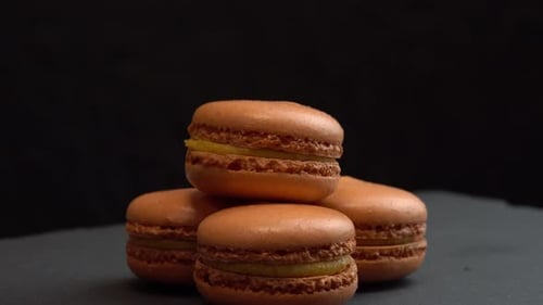 Delicious Brown Macarons Stacked on Dark Background