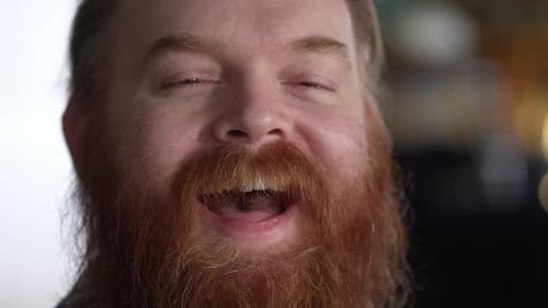 Man with thick beard laughing from up close view