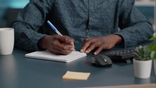 Closeup African American Black Man Hands Taking Notes on Notepad Using a Pen
