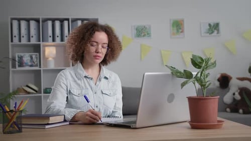 Woman Attends Video Meeting at her Desk