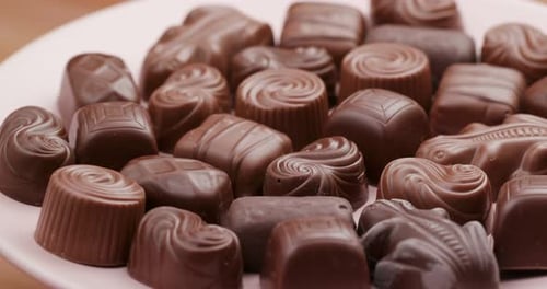 Assorted Milk Chocolates Close-Up on Pink Plate