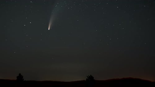 Comet lights up starry sky at night