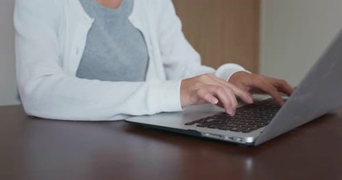 Hands Typing on Laptop Computer on Table