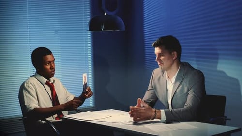 Two Men Discussing Photo Evidence in Office