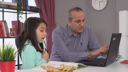 Father Helping Daughter with Homework at Home