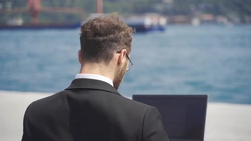 Businessman in suit working on laptop.