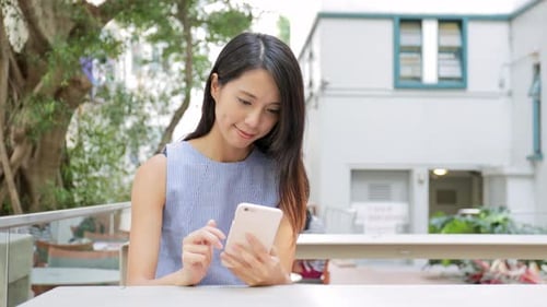 Woman using cellphone at outdoor coffee shop