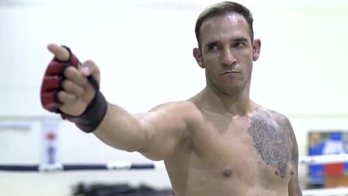 Man with Gloves Points in Boxing Ring