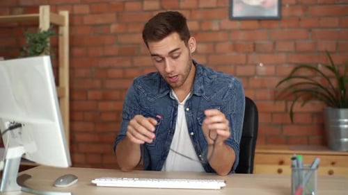 Man Working at Computer Becomes Tired