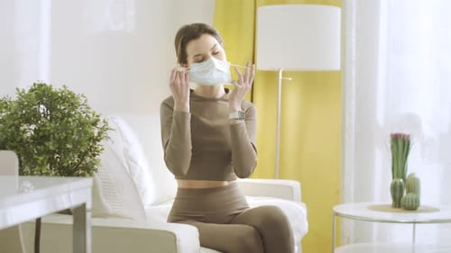 Woman Removing Face Mask in Living Room