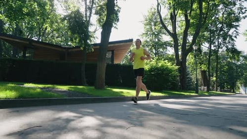 Slow Motion Jogger Running in Summer Park