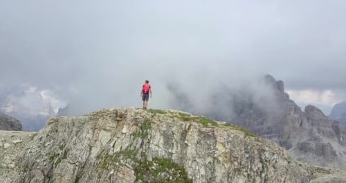 Aerial drone view of a man hiking in the mountains.
