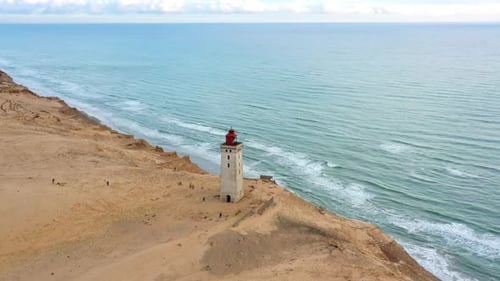 Lighthouse on Sandy Dune by a Calm Ocean