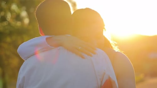 Romantic Couple Embracing in a Sunset Field