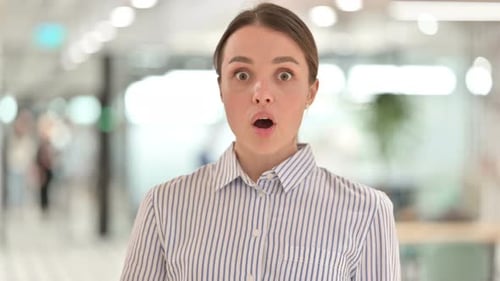 Shocked Young Woman in an Office Reacts in Surprise