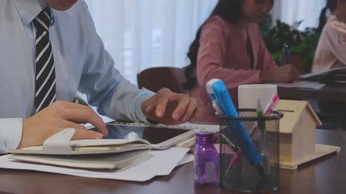 Closeup hands of businessman writing on notebook for report while working at office.