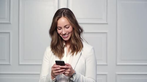 Woman in Blazer Using a Mobile Phone