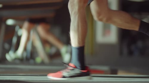 Beine eines Mannes, der im Fitnessstudio auf dem Laufband läuft