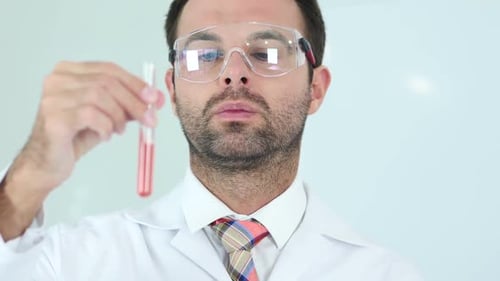 Científico estudia solución roja en tubo de ensayo en laboratorio