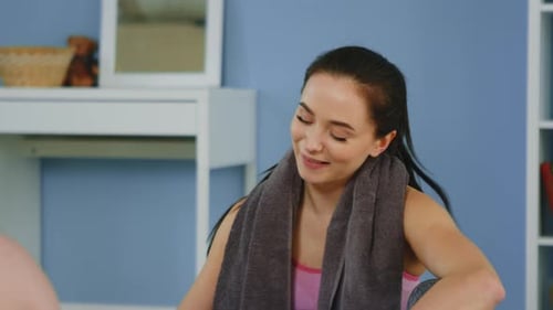 Woman Wipes Sweat and Drinks Water After Exercise
