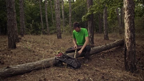 Un excursionista construye un refugio en el bosque con maderas secas