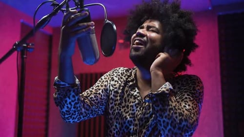 Young professional afro singer recording a new song album inside music production studio