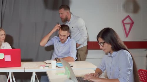 Un responsable masculin aide ses collègues du département du référencement à marcher près des tables