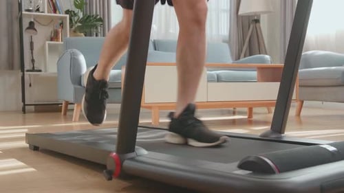 Man Running on Treadmill Indoors for Home Workout