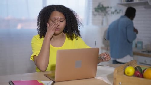 Woman Working on Laptop at Kitchen Table
