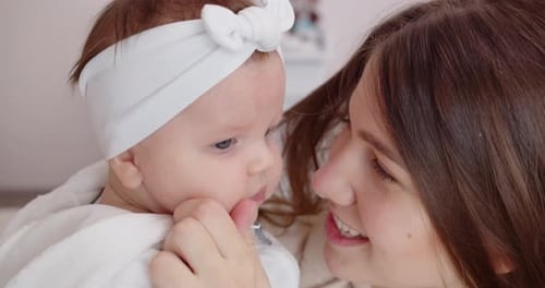 Close Up Footage of a Newborn Baby Being Held By a Mother and Gently Touching Her Face