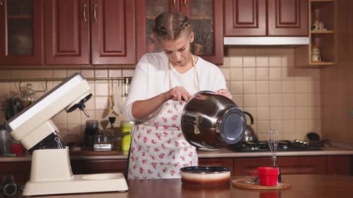 Young Woman Is Engaged in Cooking Cake at Her Home Kitchen, She Works with Cream
