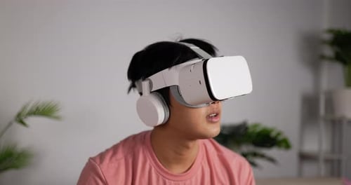 Young Man Immersed in Virtual Reality at Home