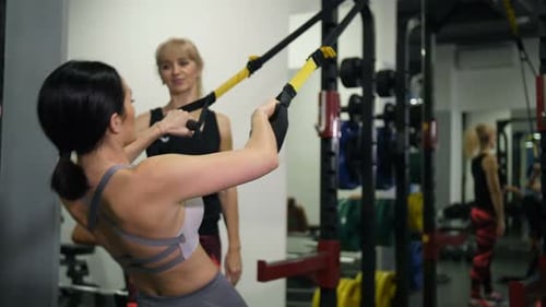 Athletic Girl Doing Pullups Under the Guidance of a Female Trainer Slow Mo