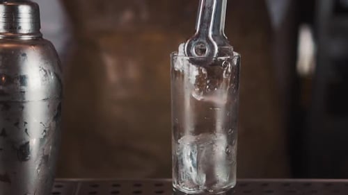 Bartender Preparing Glass with Ice for Cocktail