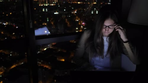 Woman Working Late at Computer in Dark Office