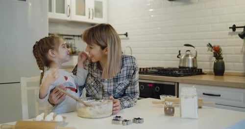 Loving Mother and Daughter Baking Together in Kitchen