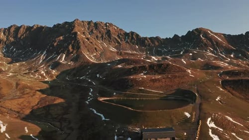 Aerial Shot of Mountains with Patches of White Snow and Blue Skie in Background
