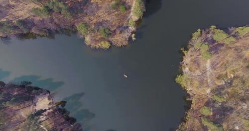 Aerial Shot of the Small Boat in the Middle of a Beautiful Wide Reflective River