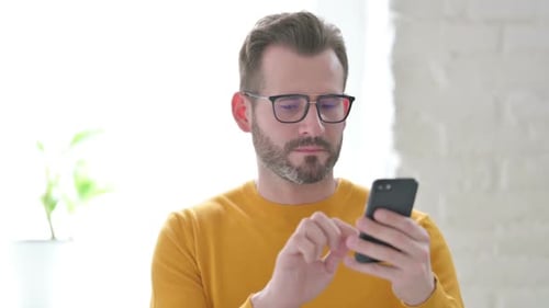 Man Celebrates Success Using Smartphone