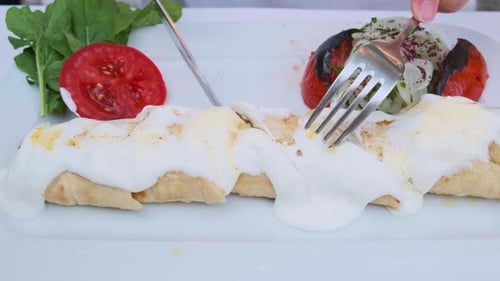 Cutting a Turkish Dish with White Sauce