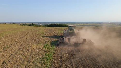 Aerial View of Tractor Plowing Agriculural Farm Field Preparing Soil for Seeding in Summer