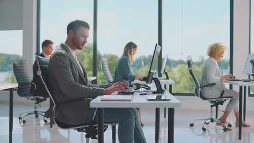 Employees Working at Desks in Bright Modern Office