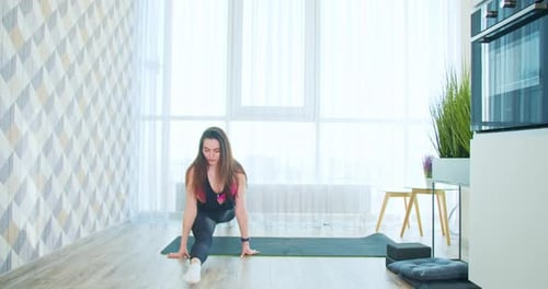 Woman Stretching on Yoga Mat in Bright Room
