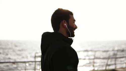 Young Man Walking By the Ocean at Sunrise