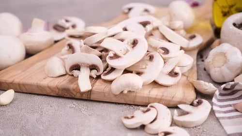 Geschnittene und gehackte Champignons auf einem Holzschneidebrett