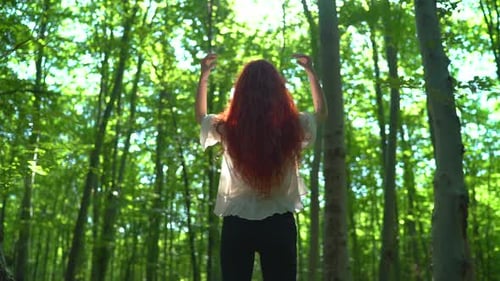 Woman in a forest, playing with her hair