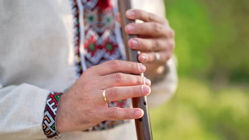 Hände des jungen Mannes spielen auf Holzflöte Ukrainerin Sopilka Outdoors