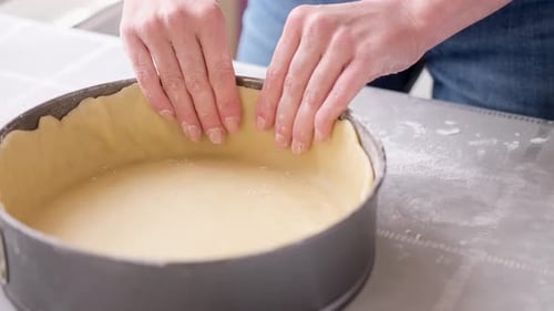 Hands Shaping Pie Crust in Pan