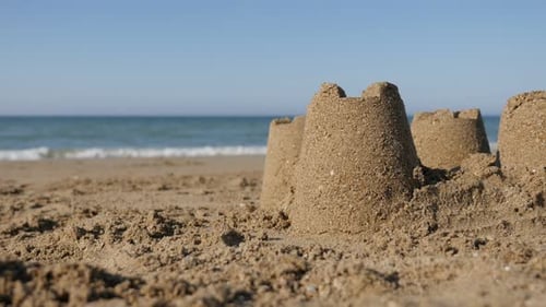 Common summer vacation symbol with sand castles on ocean beach 4K 2160p UltraHD footage - Relaxing s