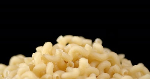 Handful of Dry Pasta Cavatappi on Table Slowly Rotates.